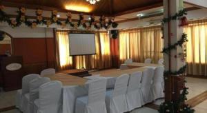 a conference room with white chairs and a projection screen at Soledad Suites in Panglao