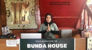 a woman is giving a peace sign in front of a building at Bunda House Syariah in Padang