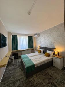 Una habitación de hotel con una cama grande y una ventana. en Hotel Aurora, en Satu Mare