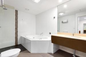 a white bathroom with a toilet and a sink at Bayside Geelong Hotel & Apartments, an Ascend Collection Hotel in Geelong +83 photos