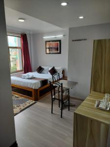 a bedroom with a bed and a table and a desk at Three Brothers Apartment and Hotel in Kathmandu