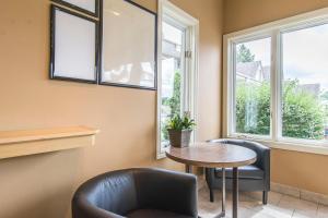 a dining room with a table and chairs and windows at Rodeway Inn King William in Huntsville