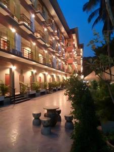 a building with a courtyard with potted plants and lights at Waenpetch place Hotel in Ubon Ratchathani