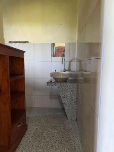 a bathroom with a sink and a mirror at Munduk Nature Lodge in Munduk +23 photos