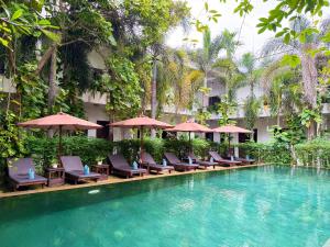シェムリアップにあるザ ムーン レジデンス＆スパのホテルのスイミングプール(椅子、パラソル付)