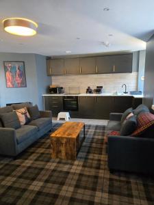 a living room with two couches and a coffee table at The Post Office Tarbet in Tarbet
