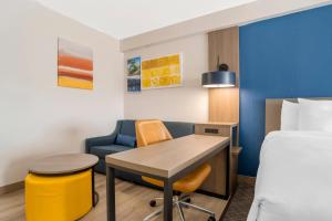 a hotel room with a bed and a desk and chair at Comfort Suites Gastonia - Charlotte in Gastonia