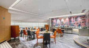 a restaurant with tables and chairs and a kitchen at City Comfort Inn Nanning Guangxi University in Nanning