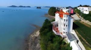 an aerial view of a house next to the water at Gallery Pension in Taean