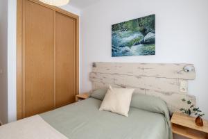 a bedroom with a bed with a wooden headboard at Alojamientos Callejón del Pozo, cerca Puy du Fou in Gálvez +56 photos