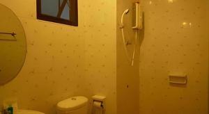a bathroom with a toilet and a mirror at Erawan Place in Mae Sot