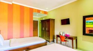 a room with a bed and a desk and a bed sidx sidx sidx at Albis Hotel in Bandung