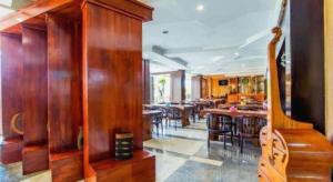 a dining room with wooden tables and chairs at Albis Hotel in Bandung