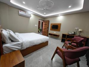 a bedroom with a bed and a chair and a tv at Sagar Stays in Jaipur +14 photos