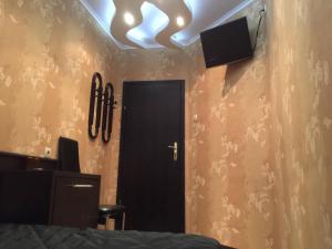a bedroom with a black door and a tv on the ceiling at Hotel Chamishki in Blagoevgrad