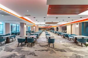 una caffetteria con tavoli e sedie in un edificio di Wudangshan Jianguo Hotel a Shiyan