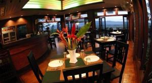 a dining room with tables and chairs in a restaurant at Thaton Hill Resort in Mae Ai