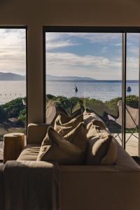 a bed in a room with a view of the ocean at Cooinda - on the beach - Bicheno in Bicheno