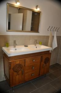 een badkamer met een wastafel en een spiegel bij Au Marronnier in Lontzen