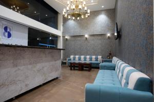 a waiting room with blue couches and a chandelier at Stamps by Eight Continents, Jodhpur in Jodhpur