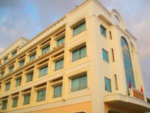 un edificio con due bandiere davanti di Seng Aroun Hotel a Pakse