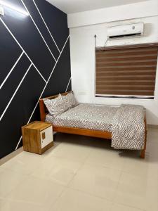 ein kleines Bett in einem Zimmer mit einer Wand in der Unterkunft HR Mukkali in Attappādi