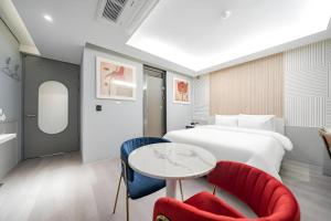 a hotel room with a bed and a table and chairs at Boutiquehotel K Ilsan in Goyang +40 photos