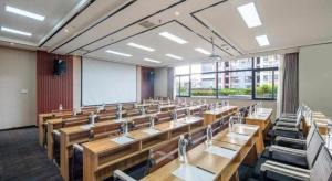 a large lecture room with wooden tables and chairs at Lavande Hotels Yuxi Times Square in Yuxi