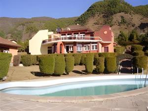 Una casa grande con piscina delante de ella. en New Dakshinkali Village Resort, en Katmandú