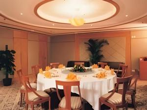 ZhaozhuangにあるZaozhuang Hotelの白いテーブルと椅子のあるダイニングルーム