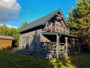 an old house with a porch on the grass at Miodowa cisza in Szafarnia
