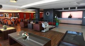 a lobby of a restaurant with tables and a bar at Hotel Formosa in Manado