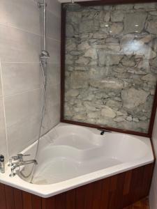 a bathroom with a bath tub with a stone shower at Chambre suite de L'argentier in Noyarey