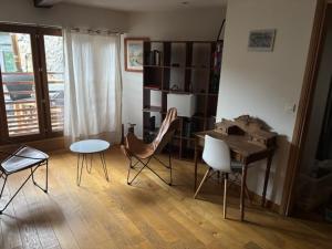 a living room with a table and chairs and a desk at Chambre suite de L'argentier in Noyarey