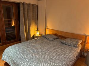 a bedroom with a bed with a lamp and a window at Chambre suite de L'argentier in Noyarey
