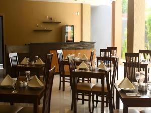 a dining room with wooden tables and chairs in a restaurant at Mataram Square Hotel in Gili Trawangan