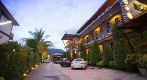 a car parked in a parking lot next to a building at The Prince Hotel in Khao Kho