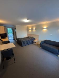 a hotel room with a bed and a couch at Shellharbour Resort and Conference Centre in Shellharbour