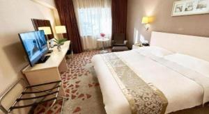 a hotel room with a bed and a flat screen tv at Super8 Hotel Anyang Hongqi Road in Anyang