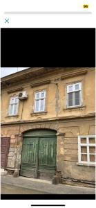 スレムスキ・カルロヴツィにあるSremski Karlovci center 4 bedrooms apartmentの緑の扉と三窓の建物
