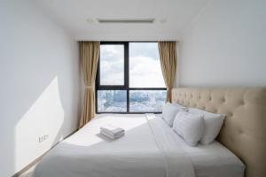 a bed in a room with a large window at The Grand Residence at Vinhomes in Ho Chi Minh City +175 photos