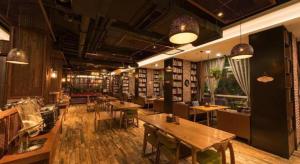 a room with tables and chairs in a library at James Joyce Coffetel Tianjin Railway Station Jinshiqiao Metro Station Branch in Tianjin