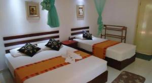 two beds in a room with two beds sidx sidx sidx at Seven Flowers Hotel in Anuradhapura