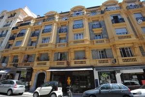 a yellow building with cars parked in front of it at Le 10 - Nice Massena in Nice