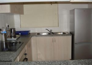 a kitchen with a sink and a refrigerator at Oswald Ramgate Beach in Margate