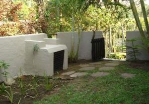 a garden with a white wall and a fence at Oswald Ramgate Beach in Margate