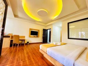 a bedroom with a bed and a desk in a room at The Continental Near Mg Marg in Gangtok