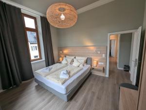 a bedroom with a large bed and a chandelier at Weinhotel St. Stephanus in Zeltingen-Rachtig +55 photos