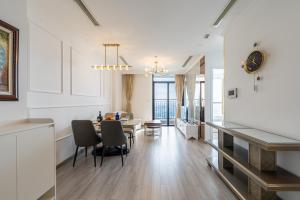 a kitchen and living room with a table and chairs at The Grand Residence at Vinhomes in Ho Chi Minh City
