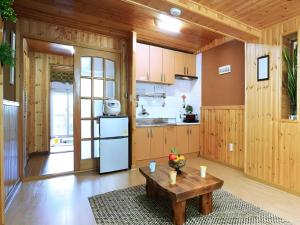 a kitchen with a table in the middle of a room at Daegwalnyeong Sky Keeper Pension in Pyeongchang 